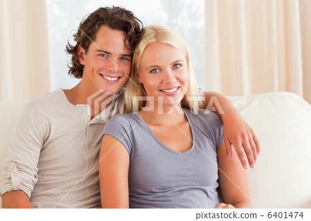 Young couple sitting on a couch Young couple sitting on a couch 6401474