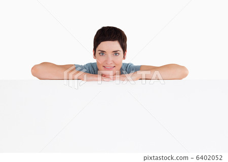 Serene woman relying on a blank panel 6402052