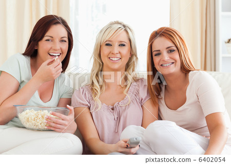 Cheerful Women watching a movie eating popcorn 6402054