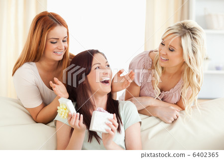 Laughing Girls giving their friend a present 6402365