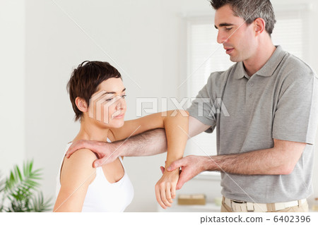 Chiropractor stretching a womans arm 6402396