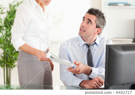 Business manager receiving a document from his secretary Business manager receiving a document from his secretary 6402727