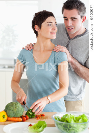 Husband peeking over his wifes shoulder 6403074
