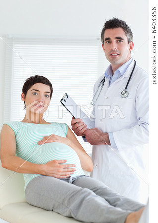 Doctor and pregnant patient looking at the camera 6403356