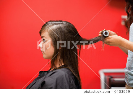 Young woman having her hair rolled Young woman having her hair rolled 6403959