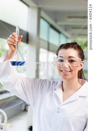 Portrait of a female science student holding a blue liquid Portrait of a female science student holding a blue liquid 6404114
