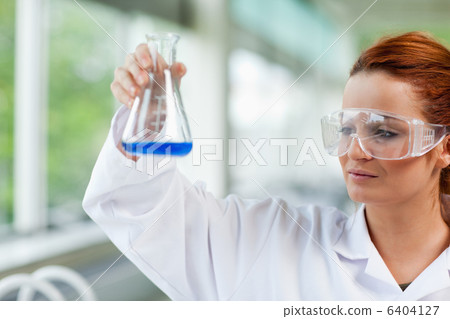 Science student looking at an Erlenmeyr flask 6404127