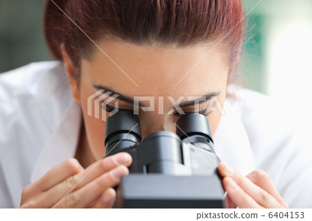 Close up of a scientist looking into a microscope Close up of a scientist looking into a microscope 6404153