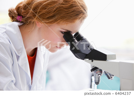 Close up of a science student looking into a microscope Close up of a science student looking into a microscope 6404237