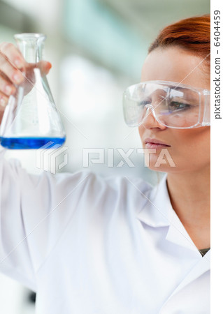 Portait of a science student looking at an Erlenmeyr flask Portait of a science student looking at an Erlenmeyr flask 6404459
