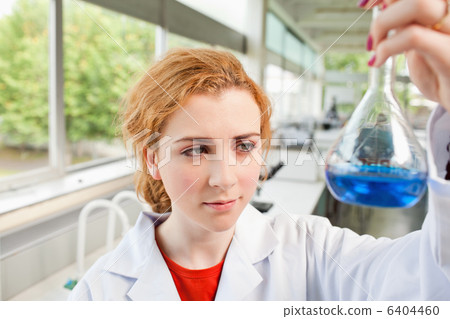 Cute science student holding a blue liquid Cute science student holding a blue liquid 6404460