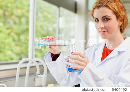 Cute scientist pouring liquid 6404492