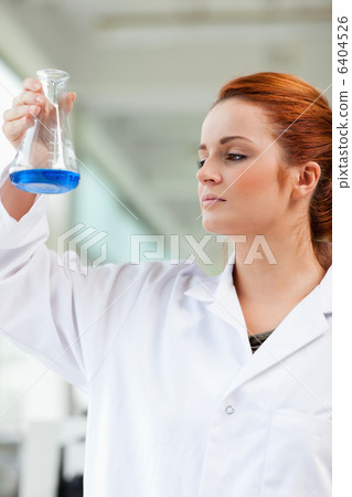 Portrait of a scientist looking at a blue liquid Portrait of a scientist looking at a blue liquid 6404526
