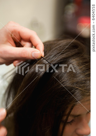 Portrait of a hairdresser putting a hairpin 6404558