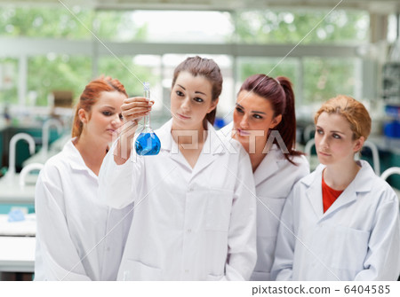 Cute science students looking at a flask Cute science students looking at a flask 6404585