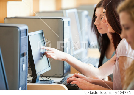 Student pointing at something to her friend 6404725