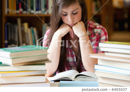 Studious woman surrounded by books 6405037