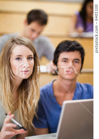Portrait of students posing with a laptop 6405100