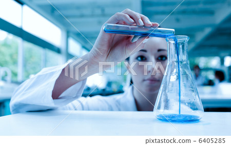 Scientist pouring a liquid in an Erlenmeyer flask with a test tube 6405285