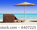 empty beach chair with straw sunshade at the sea 6407225
