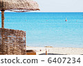 empty beach chair with straw sunshade at the sea 6407234