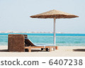 empty beach chair with straw sunshade at the sea 6407238