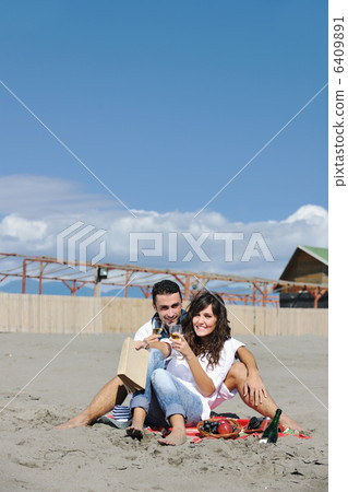 young couple enjoying picnic on the beach 6409891