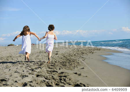 cute little girls running on beach cute little girls running on beach 6409909