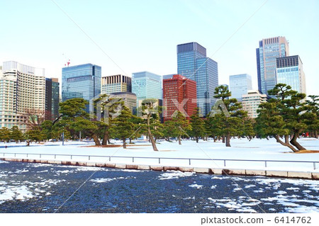 在東京的雪域景觀·皇宮外松林和明亮的建築群的剩余雪·橫向位置 6414762