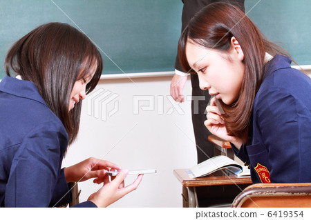 Two girls high school students watching smaho in class Two girls high school students watching smaho in class 6419354
