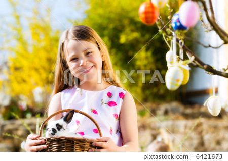 Child on Easter egg hunt with bunny 6421673