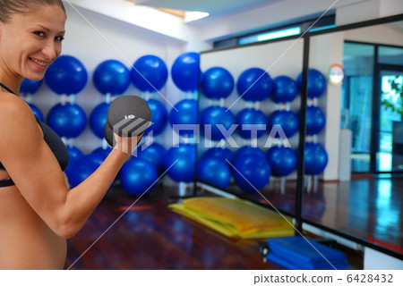 woman doing exercise with dumbbell 6428432