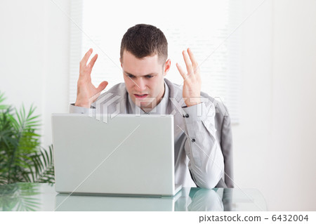 Businessman having problems with his laptop 6432004
