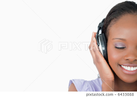 Close up of young woman enjoying music on white background 6433088