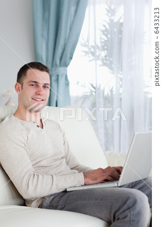Portrait of a happy man typing on his notebook 6433213