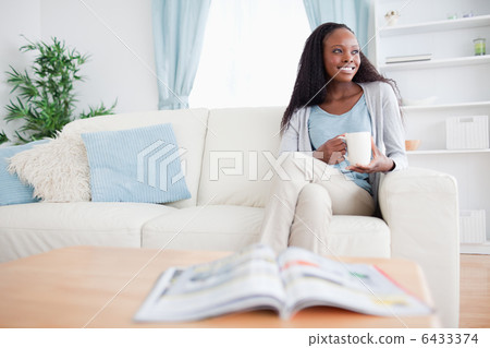 Woman with a cup on the couch 6433374