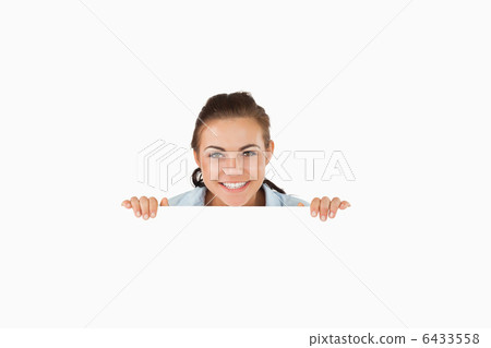 Smiling businesswoman looking over wall 6433558