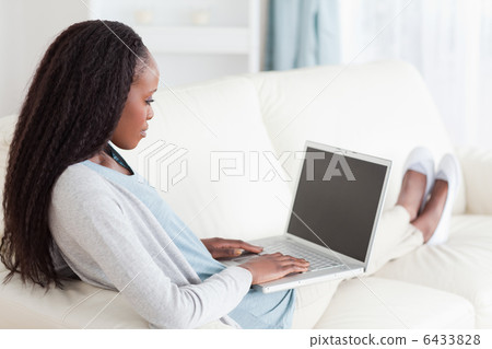Woman on sofa surfing the internet 6433828