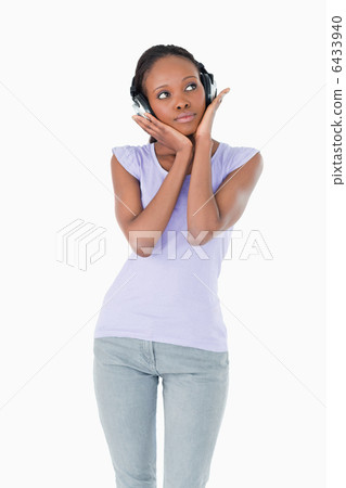 Close up of woman enjoying music with headphones on white backgr 6433940