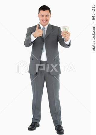 Businessman with banknotes giving thumb up Businessman with banknotes giving thumb up 6434213