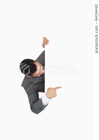 Businessman looking around the corner and pointing Businessman looking around the corner and pointing 6434448