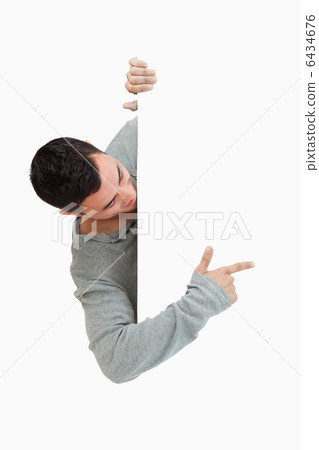 Young male pointing around the corner 6434676