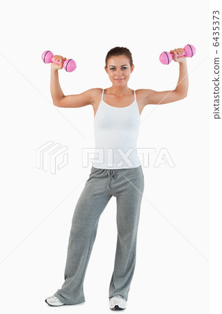 Portrait of a young woman working out with dumbbells 6435373