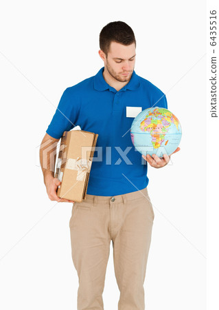 Young salesman with packet and globe in his hands Young salesman with packet and globe in his hands 6435516