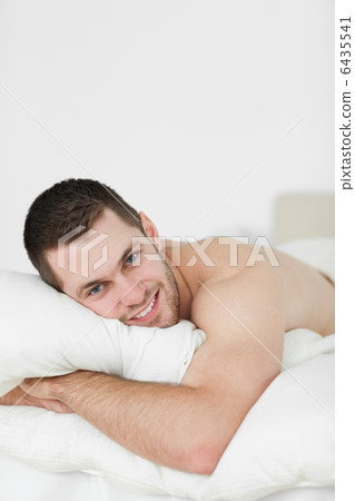 Portrait of a beautiful man lying on his belly Portrait of a beautiful man lying on his belly 6435541