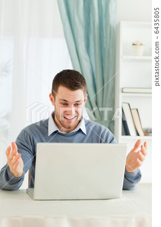 Businessman surprised about his laptop in his homeoffice Businessman surprised about his laptop in his homeoffice 6435805