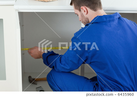 Focused repair man measuring something 6435960