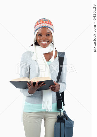 Smiling young student in winter clothing and book 6436129