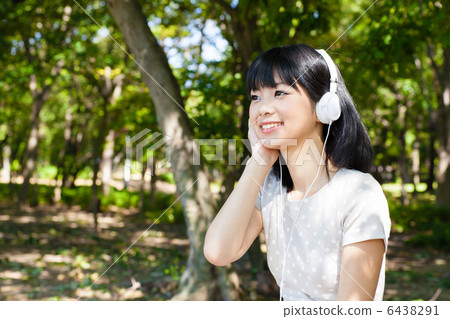 一個女人在公園聽音樂 一個女人在公園聽音樂 6438291
