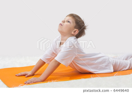 Childrens yoga. The little boy does exercise. Childrens yoga. The little boy does exercise. 6449640